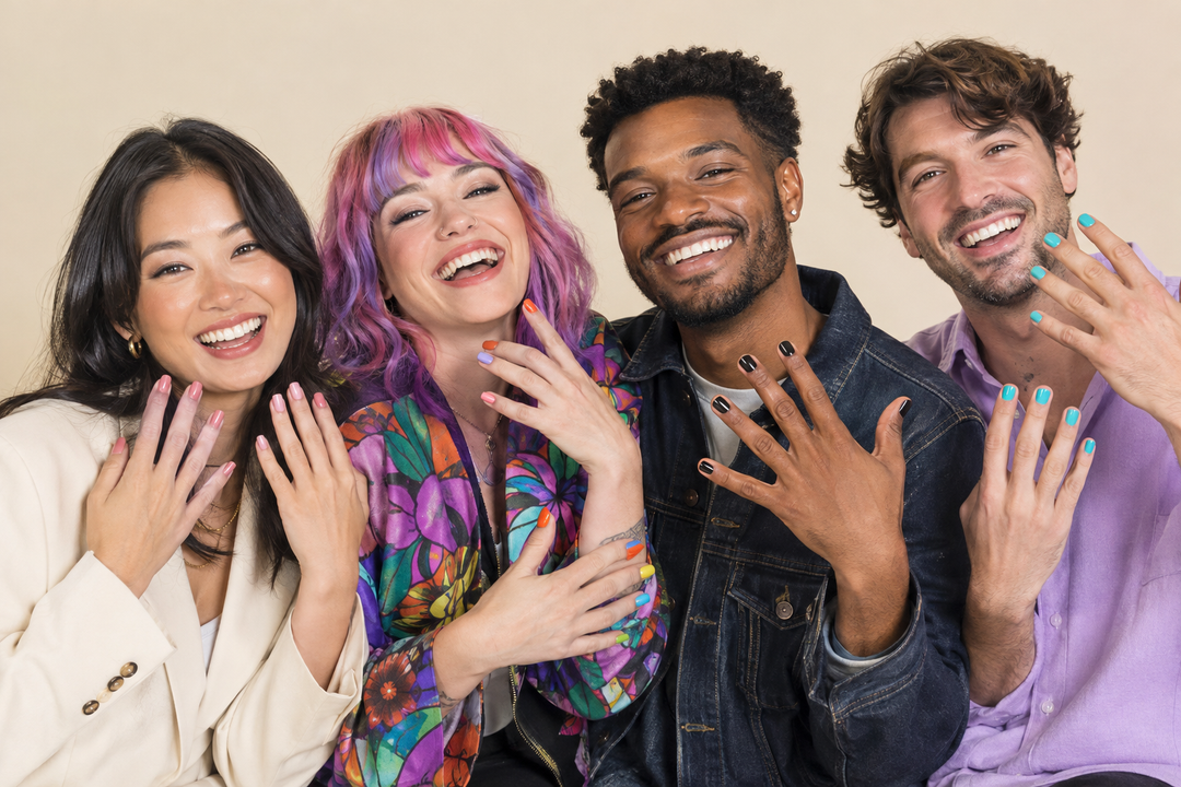 Four laughing friends, two men and two women, showing pink, multicolored, black, and turquoise manicures with distinct clothing styles.